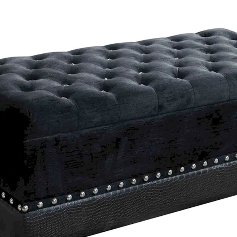 Banc de rangement en similicuir noir, orné de clous décoratifs et d'une assise capitonnée.